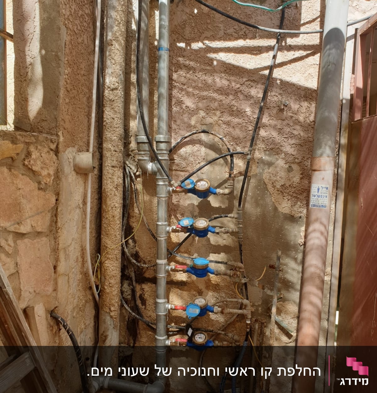 צינורות מים ומדי מים מותקנים על קיר חיצוני